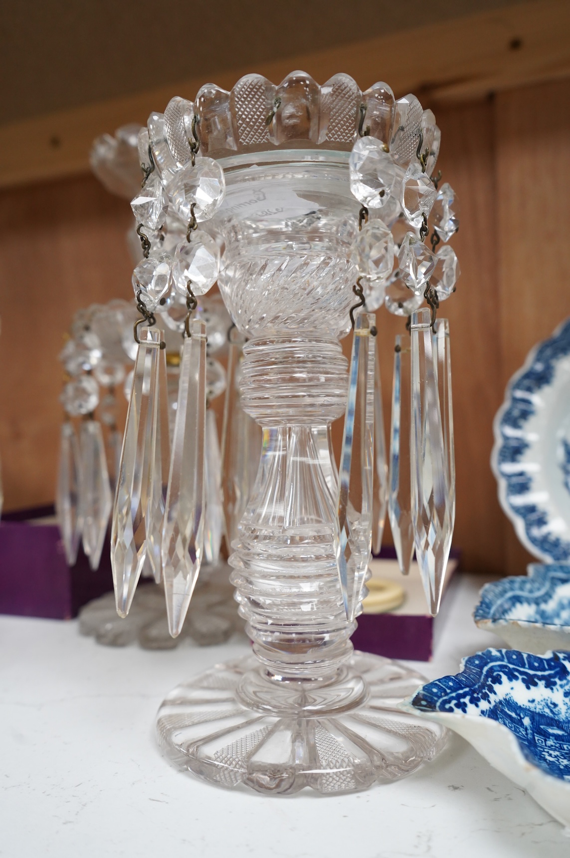 A pair of Victorian cut glass lustre candlesticks and one larger candlestick, 24cm high